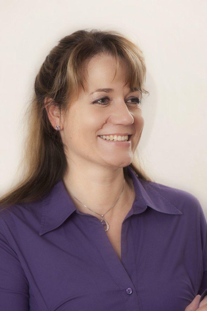 Claudia Wittmann laughing looking to the right wearing a lilac blouse